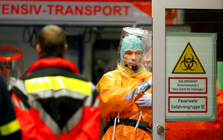 Medical staff members wearing sealed protective suits work during the arrival of an Ebola patient in Frankfurt, Germany, Oct. 3, 2014.