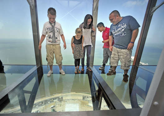 Re-launch Of Blackpool Tower Eye Unveils A Full Floor 4 Tonne Glass Skywalk On The Towers Viewing Platform. The Hill Family From Blackpool Look Down Through The Glass Door.