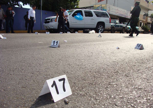 Police investigators work at the crime scene where Sinaloa State Tourism Minister Antonio Ibarra Salgado and his driver were shot dead by several hit men in Culiacan.