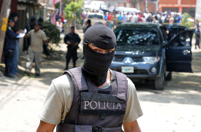 A National Police officer works at the crime scene in which five people were shot dead in the suburb of La Haya, in northern Tegucigalpa, Distrito Central.