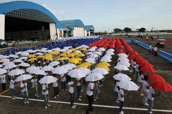 Students holding umbrellas rehearse a dance hours prior to the arrival of Pope Francis at a military airbase in Manila on January 15, 2015.