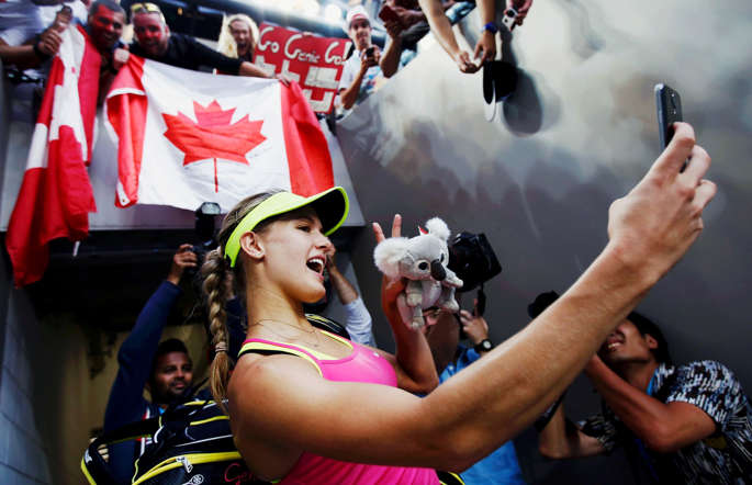 Eugenie Bouchard of Canada takes a "selfie" using a spectator's phone after defeating Kiki Bertens of the Netherlands during their women's singles second round match at the Australian Open 2015 tennis tournament in Melbourne January 21, 2015.