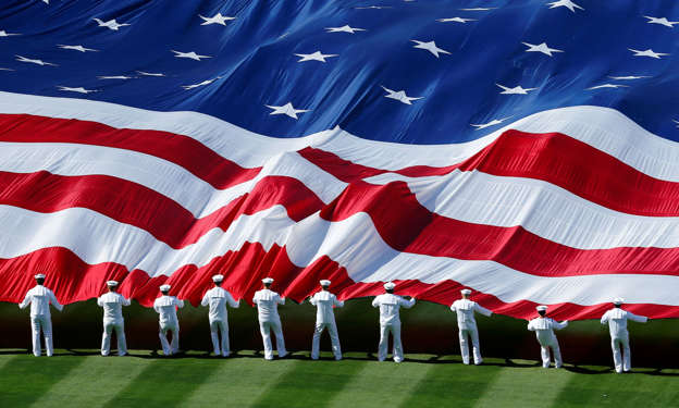 An American flag is unfurled before a baseball game in San Diego, Califdornia, April 9, 2013.