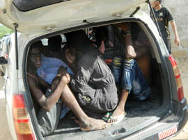 Students of the Garissa University College take shelter in a vehicle after fleeing from an attack by gunmen in Garissa, Kenya, Thursday, April 2, 2015.