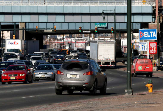 Vehicle traffic moves along Route 21 in downtown Newark, N.J., where competing gas stations list the cash price for regular unleaded at $1.71 and $1.72, Friday, Jan. 23, 2015. Julio Cortez/AP