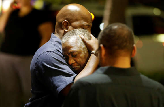 Worshippers embrace following a group prayer across the street from the scene of a shooting Wednesday, June 17, 2015, in Charleston, S.C.