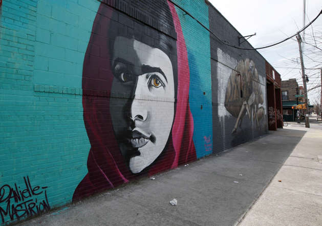 Danielle Mastrion's portrait of education activist and heroine Malala Yousafzai, the Pakistani schoolgirl who stood up to the Taliban and defended her right to an education, Tuesday, April 22, 2014, in Brooklyn's cutting-edge Bushwick neighborhood in New York.  The neighborhood's street art, low-key cafes, up-and-coming restaurants and the space of industrial warehouses have drawn those who can't afford nearby Williamsburg to the neighborhood, home to many artists. (/)