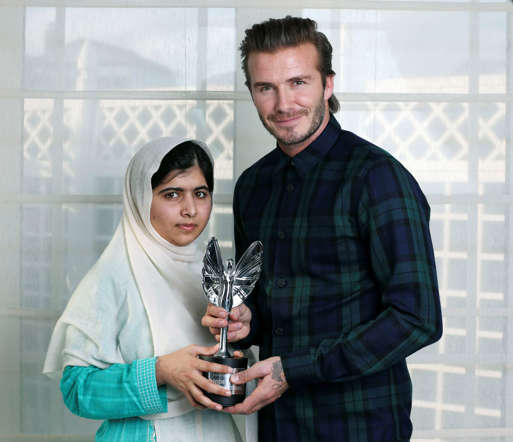 FILE- In this undated photo released on Monday, Oct. 7, 2013, by the Daily Mirror newspaper, David Beckham presents a Mirror Pride of Britain Teenager of Courage Award to Malala Yousafzai, Pakistani schoolgirl who was shot by the Taliban for going to school.  Teenage activist Malala Yousafzai has jointly won the Nobel Peace Prize for her "heroic struggle" for girls' rights to education, it is announced Friday Oct. 10, 2014.