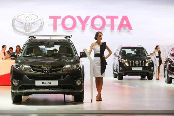 An employee models beside a Toyota RAV4 automobile at the Toyota Motor Corp. at the Moscow International Auto Salon (MIAS) in Moscow, Russia, on Wednesday, Aug. 27, 2014. As Russia's economic growth comes to a halt amid trade sanctions stemming from the government's disputes over Ukraine, research company IHS now forecasts that the car market won't reach the 3 million mark until 2018.
