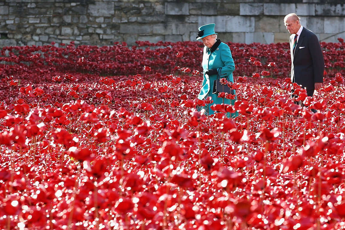 England's Queen Elizabeth II and Prince Philip walk through the Blood Swept Lands and Seas of Red at the Tower of London.