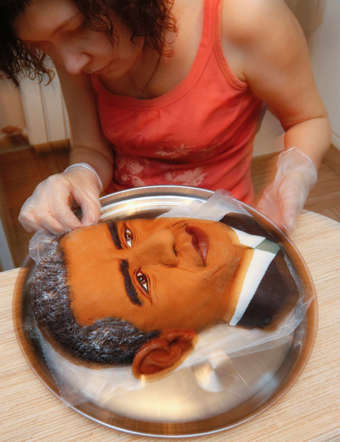 Russian artist Yelena Zelenskaya puts the finishing touches on a pie that looks like U.S. president Barack Obama.