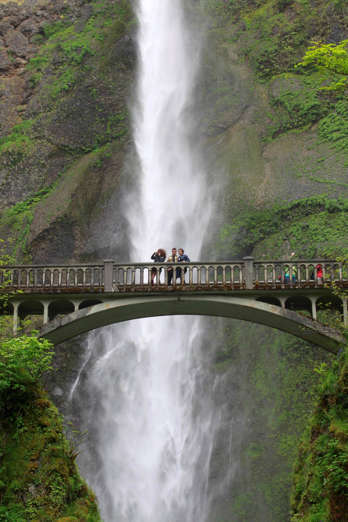 People gather to take photos from the lower falls bridge in front of Multnomah Falls along the Columbia River Gorge Tuesday, June 7, 2011, near Bridal Veil, Ore. States across the west are on the watch for potential flooding in the coming weeks once a record mountain snowpack starts melting and sending water gushing into rivers, streams and low-lying communities. (AP Photo/Rick Bowmer)