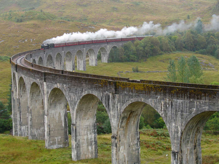 Train Jacobite on Glenfinnan viaduct is going from Fort William to Malaig. Scotland. United Kingdom.