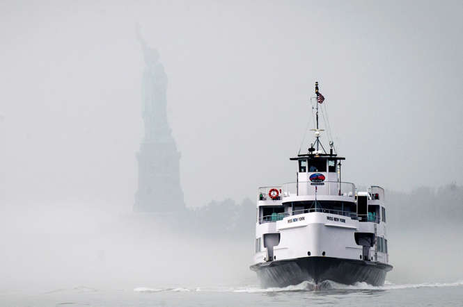 La Estatua de la Libertad es visto como un barco Liberty Island Ferry emerge de la niebla en el puerto de Nueva York 12 de noviembre 2014.