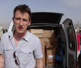 In this undated file photo provided by his family, Peter Kassig stands in front of a truck filled with supplies for Syrian refugees.