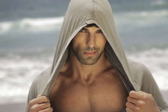 Sexy male model outdoors wearing a hooded shirt