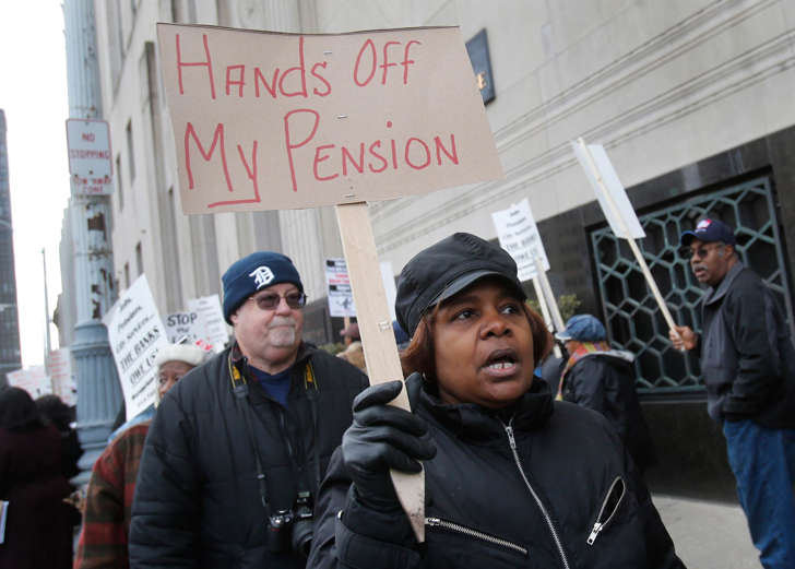 Workers protest against the cutting of their pension benefits in Detroit, Michigan.