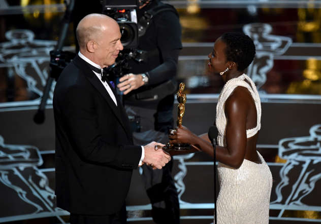 Lupita Nyong'o, right, presents J.K. Simmons with the award for best actor in a supporting role for “Whiplash” at the Oscars on Sunda
