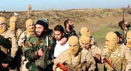 This image posted by the Raqqa Media Center, which monitors events in territory controlled by Islamic State militants with the permission of the extremist group, shows militants with a captured pilot, center, wearing a white shirt in Raqqa, Syria, on Wednesday. Islamic State group militants captured a Jordanian pilot, Mu'ath Safi Yousef al-Kaseasbeh, after his warplane went down in Syria, Jordan said Wednesday, the first such capture since the international coalition's air campaign against the group began. The pilot's family confirmed that it is al-Kaseasbeh shown in the image.