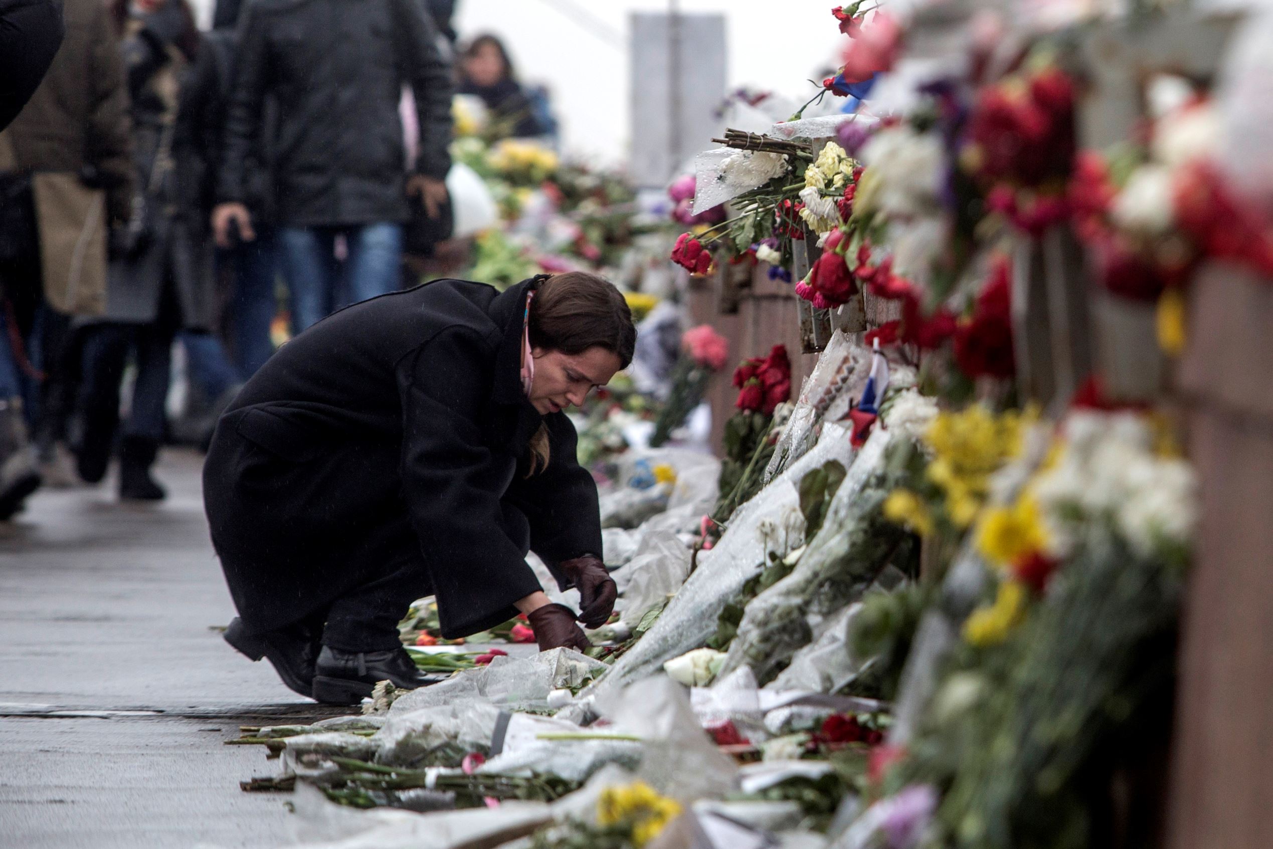 A woman lays flowers at the place where Boris Nemtsov, a charismatic Russian opposition leader and sharp critic of President Vladimir Putin, was gunned down, Feb. 27, 2015 near the Kremlin, in Moscow, Russia.