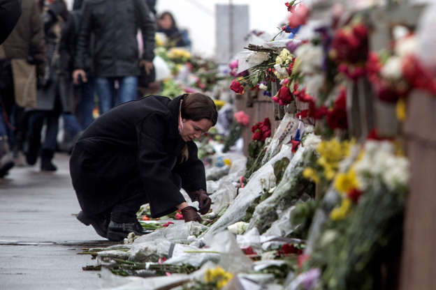 A woman lays flowers at the place where Boris Nemtsov, a charismatic Russian opposition leader and sharp critic of President Vladimir Putin, was gunned down, Feb. 27, 2015 near the Kremlin, in Moscow, Russia.