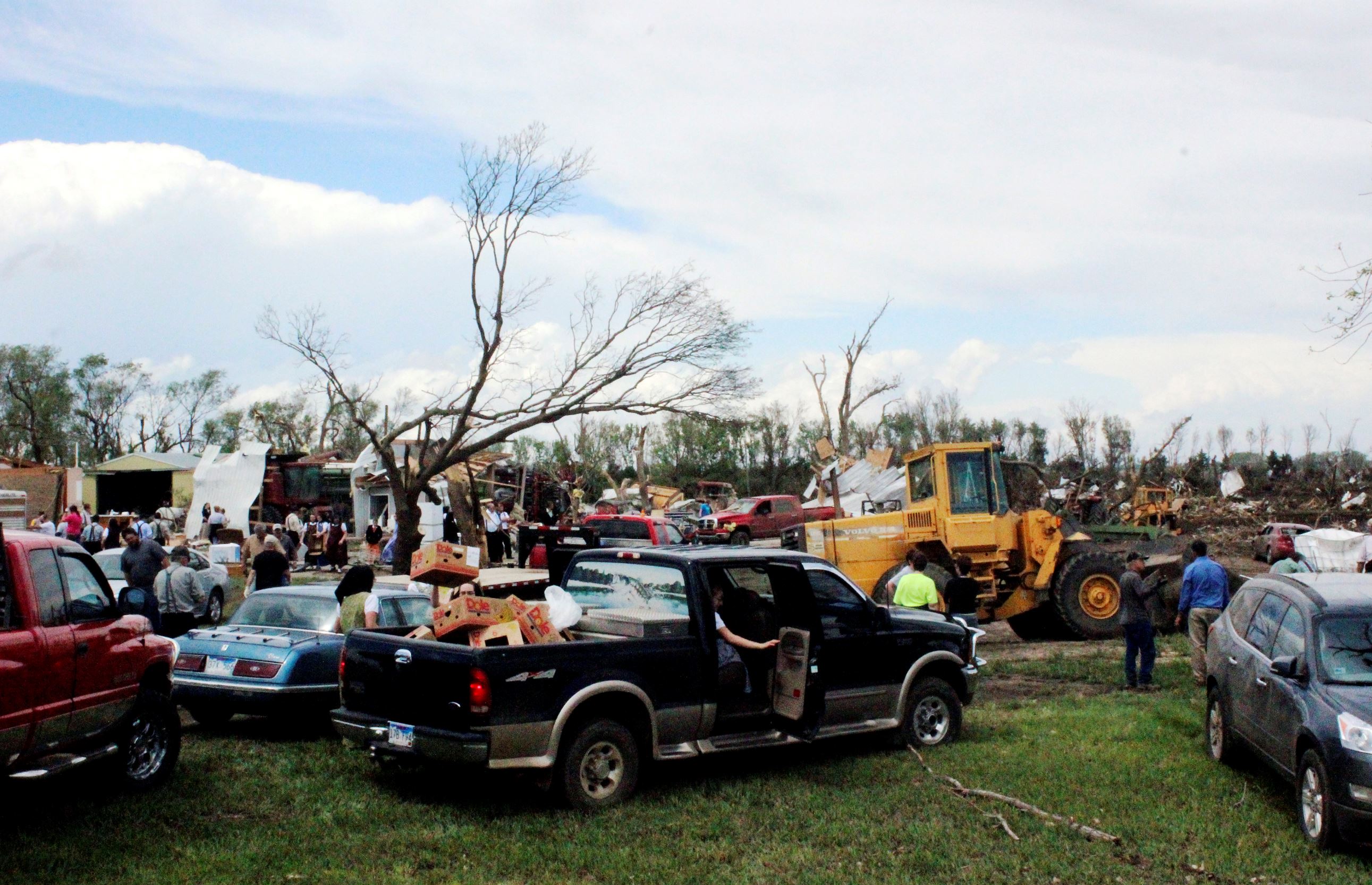 Dozens of people gather to help with cleanup efforts at a farm that was severely damaged by a tornado Sunday, May 10, 2015, in Delmont, S.D. South Dakota was the center of weather extremes Sunday, with a tornado hitting the small town on the eastern side of the state and more than a foot of snow blanketing the Black Hills to the west.