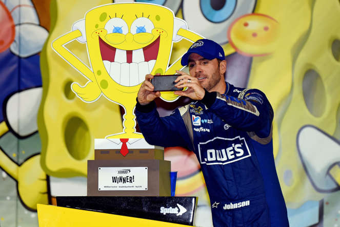 Jimmie Johnson, driver of the #48 Lowe's Chevrolet, takes a selfie with the trophy in Victory Lane after winning the NASCAR Sprint Cup Series SpongeBob SquarePants 400 at Kansas Speedway on May 9, 2015, in Kansas City, Kansas.
