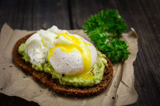Healthy, clean eating: rye toast with avocado and poached egg top view