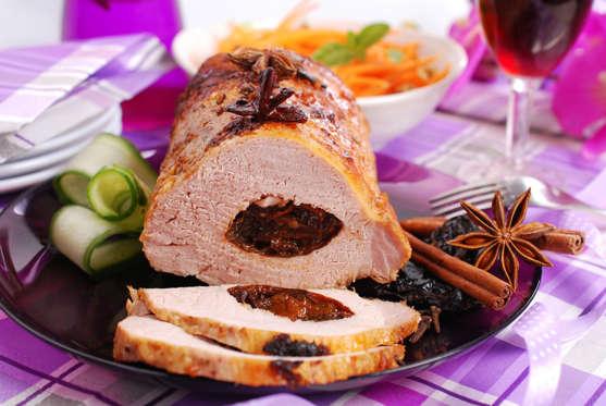 roasted pork loin stuffed with prune and spices on festive table