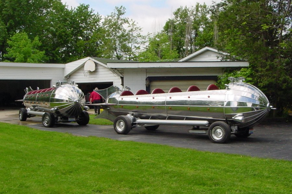 The Rocket Car, was created from an authentic space rocket swinging ride, salvaged from the old "Euclid Beach Amusement Park"  that existed in the Cleveland area until about 1969.  Ron Heitman took a dream and did what he likes best, turned it into a car!! A 1973 Oldsmobile Toronado drive train was used to transform The Rocket Car into a legal street vehicle. The original rocket frame was mated to the Toronado sub-frame. The engine is a modified 455 cu.in. Olds with an automatic front wheel drive transaxle. This conversion gives The Rocket Car disc brakes, power steering and a torsion bar suspension with Carria coil over-shocks. The steering is coupled together using gears and chain from some heavy equipment. The rear axle is a solid tube axle with coil springs and airbags from the rear of the Toronado.  The Rocket Car is 28 feet long nose to tail, and covered entirely with polished stainless steel panels. Along with the driver it will seat 10 adults or 15 kids very comfortably. All of the seats are upholstered in heavy red naughahide with seatbelts and automatic lock bars.  To make life even better, Ron found another one of the old Euclid Beach rockets and created a second Rocket Car!  The two are almost indistinguishable going down the road.