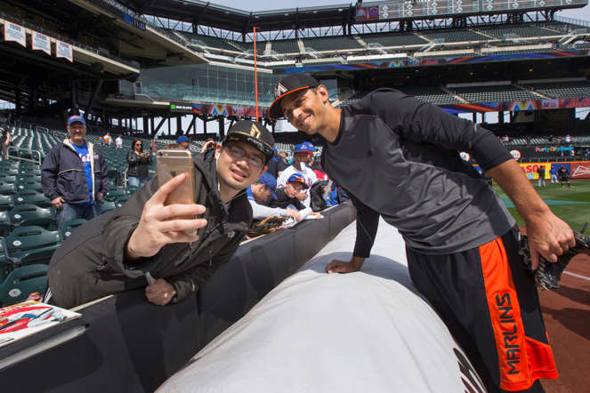 Steve Cishek of the Miami Marlins takes a photo with a fan before a game against the New York Mets on April 19, 2015, at Citi Field in New York City.