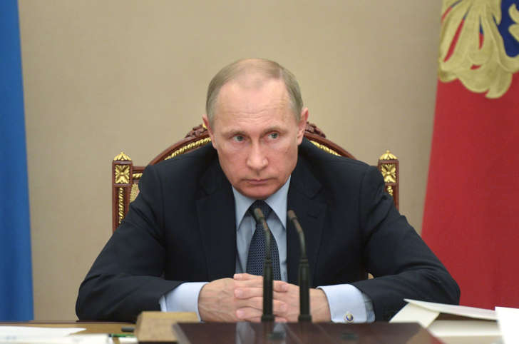 In this Wednesday, May 27, 2015 pool photo Russian President Vladimir Putin listens during a meeting in the Kremlin, Moscow, Russia. Putin says the United States is meddling in FIFA's affairs in an attempt to take the 2018 World Cup away from his country. Putin said in televised comments Thursday, May 28, 2015, that it is "odd" that the probe was launched at the request of U.S. officials for crimes which do not involve its citizens and did not happen in the United States.