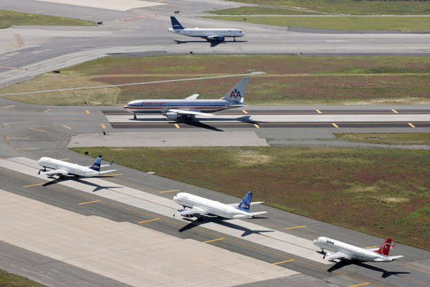 FILE - planes taxi on runways at John F. Kennedy International Airport in New York. Mark Lennihan/AP