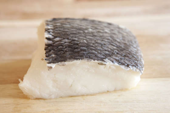 Raw chilean sea bass on a cutting board.
