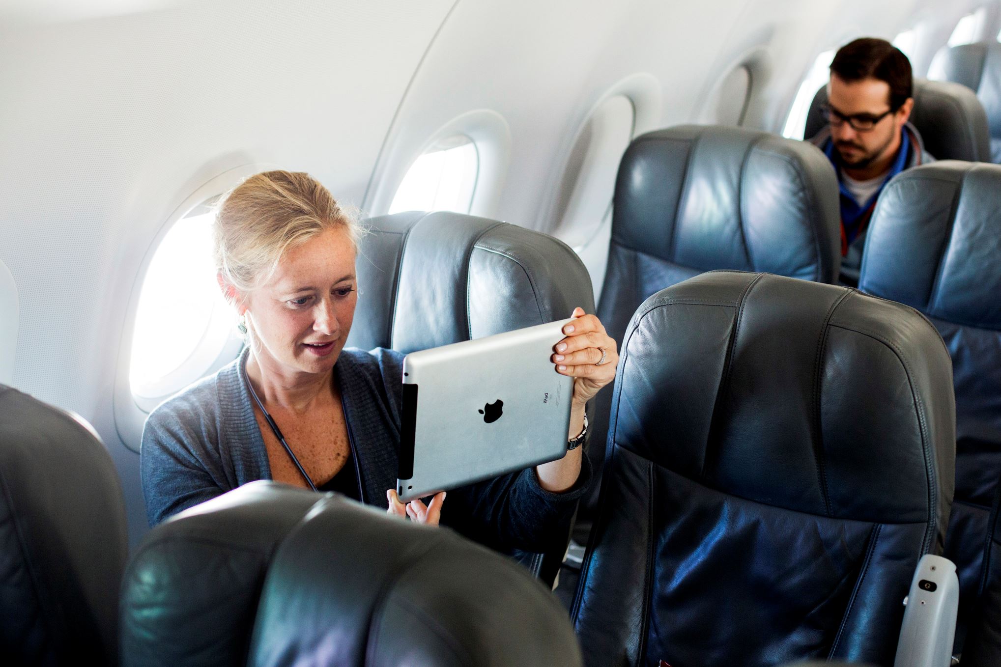 A woman uses her iPad on a special JetBlue media flight out of John F. Kennedy International Airport in New York.