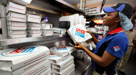 In this file photo taken Sunday, Feb. 10, 2013, a worker prepares boxes at a Domino's pizza restaurant in Lagos, Nigeria.