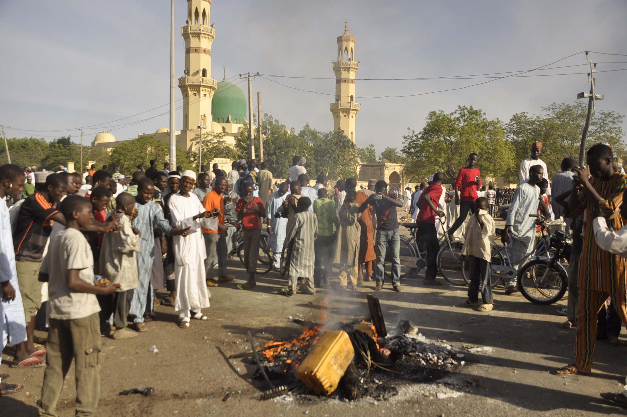 People gather at the site of a bomb explosion in Kano, Nigeria on Friday.