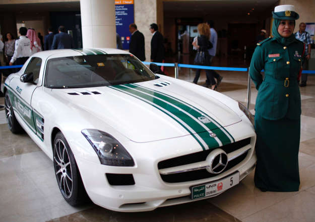 A police officer stands near a Mercedes car used by Dubai police, during the Arabian Travel Market exhibition in Dubai May 6, 2013. REUTERS/Ahmed Jadallah (UNITED ARAB EMIRATES - Tags: CRIME LAW TRANSPORT TRAVEL BUSINESS)