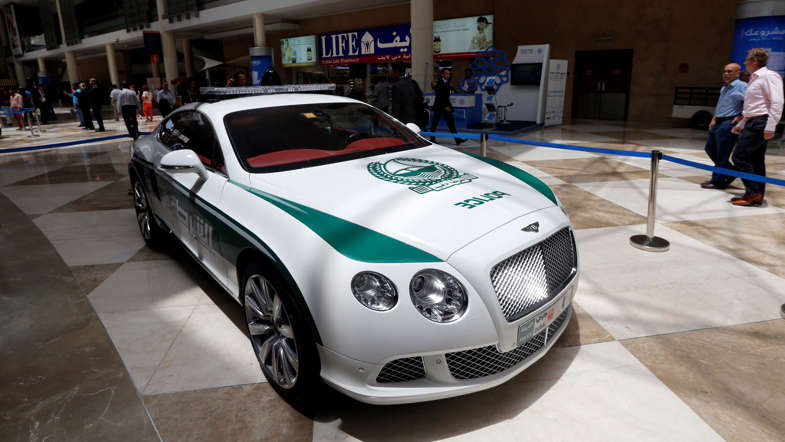 People walk past the new Dubai police Bentley patrol car on display during the Arabian Travel Market (ATM) at the Dubai World Trade Centre in the Emirati city on May 6, 2013. Dubai police have introduced top end sports cars to their patrol fleet to further strengthen the image of 'luxury and prosperity' of the Emirate. AFP PHOTO/KARIM SAHIB        (Photo credit should read KARIM SAHIB/AFP/Getty Images)